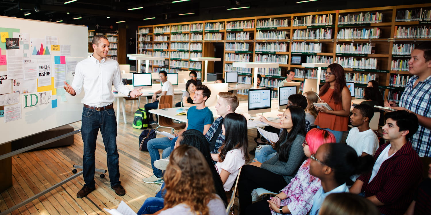 Librarian presenting to students in library.